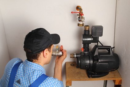 Mann schließt eine Hauswasserpumpe an | Quelle: Fotolia.com Mann schließt eine Hauswasserpumpe an | Quelle: Fotolia.com