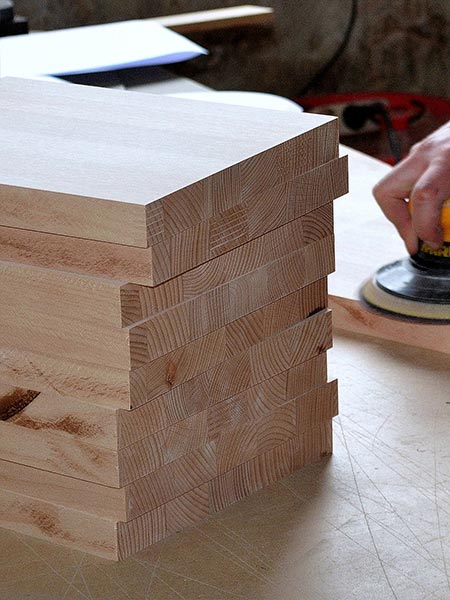 Hier sieht man einen Stapel Holzbretter vor dem Bearbeiten mit einer Flachdübelffräse oder Lamellofräse